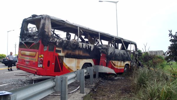 Investigators inspect a bus carrying tourists from mainland China that crashed and caught fire along an expressway on its way to the airport in Taiwan's city of Taoyuan on July 19, 2016 Investigators inspect a bus carrying tourists from mainland China that crashed and caught fire along an expressway on its way to the airport in Taiwan's city of Taoyuan on July 19, 2016 - Sputnik International