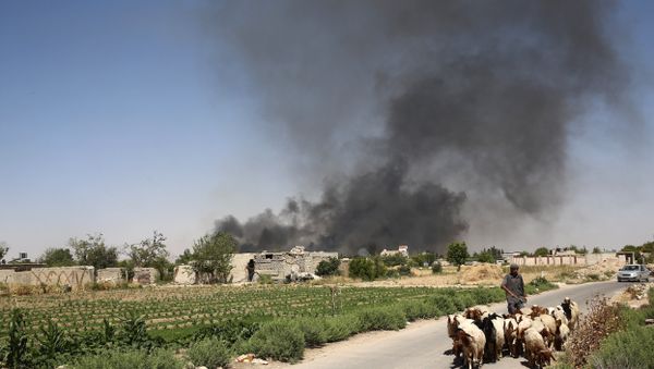A young Syrian shepherd leads his flock on June 14, 2016 as smoke billows from a farm following a reported airstrike in Sheifuniya, near the rebel-held town of Douma, east of the capital Damascus - Sputnik International