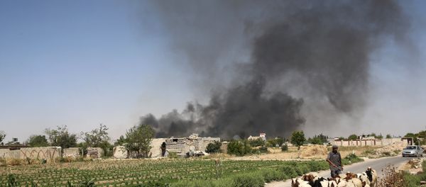 A young Syrian shepherd leads his flock on June 14, 2016 as smoke billows from a farm following a reported airstrike in Sheifuniya, near the rebel-held town of Douma, east of the capital Damascus - Sputnik International