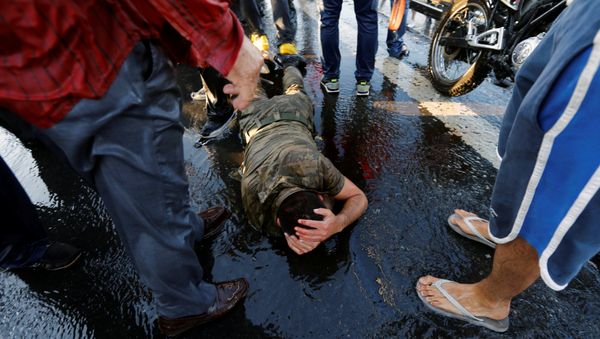 A soldier protects himself from the mob after troops involved in the coup attempt surrendered on the Bosphorus Bridge in Istanbul, Turkey July 16, 2016 - Sputnik International