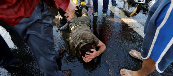 A soldier protects himself from the mob after troops involved in the coup attempt surrendered on the Bosphorus Bridge in Istanbul, Turkey July 16, 2016 - Sputnik International