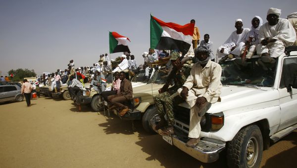 Sudanese wave national flags during a rally organised during the visit of Sudanese president in the town of Zalingei, capital of Central Darfur state on April 3, 2016 - Sputnik International
