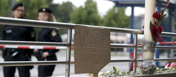 A sign reading 'Why' and flowers are placed on on a wall near the Olympia shopping mall, where yesterday's shooting rampage started, in Munich, Germany July 23, 2016. - Sputnik International