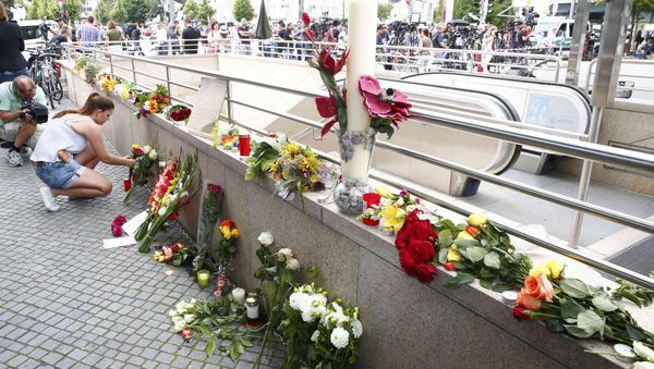 A women places flowers near the Olympia shopping mall, where yesterday's shooting rampage started, in Munich, Germany July 23, 2016. A women places flowers near the Olympia shopping mall, where yesterday's shooting rampage started, in Munich, Germany July 23, 2016. - Sputnik International