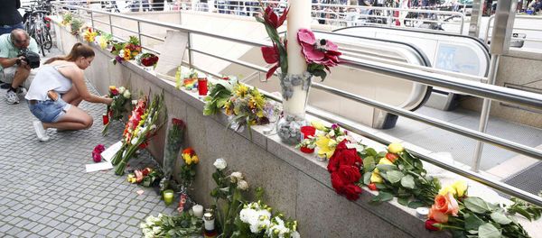 A women places flowers near the Olympia shopping mall, where yesterday's shooting rampage started, in Munich, Germany July 23, 2016. A women places flowers near the Olympia shopping mall, where yesterday's shooting rampage started, in Munich, Germany July 23, 2016. - Sputnik International