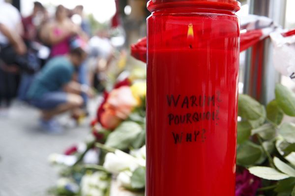 A candle with the words 'Why?' written upon it is placed next to flowers near the Olympia shopping mall, where yesterday's shooting rampage started, in Munich, Germany July 23, 2016. - Sputnik International