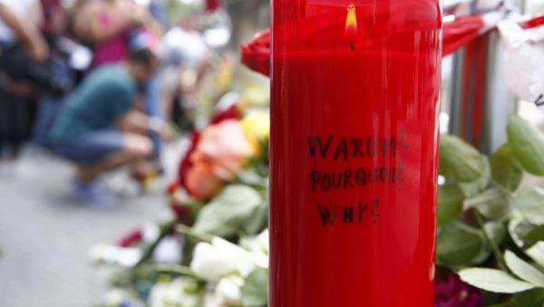 A candle with the words 'Why?' written upon it is placed next to flowers near the Olympia shopping mall, where yesterday's shooting rampage started, in Munich, Germany July 23, 2016. - Sputnik International