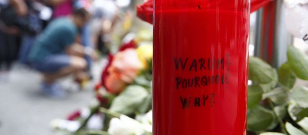 A candle with the words 'Why?' written upon it is placed next to flowers near the Olympia shopping mall, where yesterday's shooting rampage started, in Munich, Germany July 23, 2016. - Sputnik International