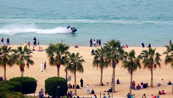 A jet-skier drives past people on a beach in the Salmiya district of Kuwait City - Sputnik International