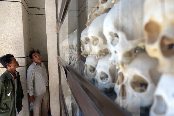Cambodian men looks at skulls of victims killed by the Khmer Rouge regime at the Choeung Ek killing fields memorial Cambodian men looks at skulls of victims killed by the Khmer Rouge regime at the Choeung Ek killing fields memorial - Sputnik International