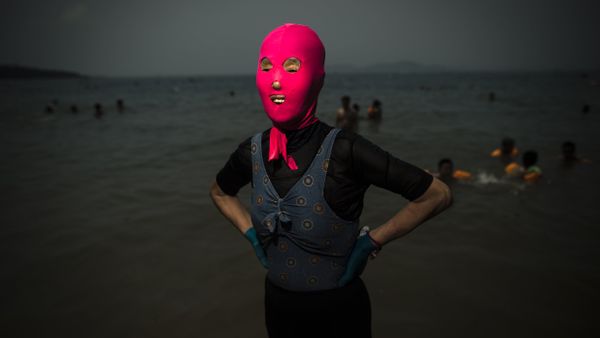A woman wearing a facekini poses at the beach in Qingdao, eastern China's Shandong province - Sputnik International