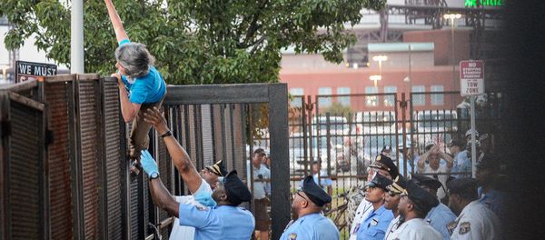 A protester is detained by police after climbing over a barrier near the site of the Democratic National Convention in Philadelphia, Pennsylvania, U.S., July 26, 2016 - Sputnik International