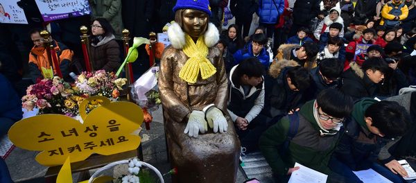 South Korean students sit near a statue (C) of a teenage girl symbolizing former comfort women who served as sex slaves for Japanese soldiers during World War II, during a weekly anti-Japanese demonstration in front of the Japanese embassy in Seoul (File) - Sputnik International