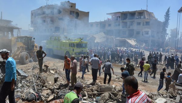 Smoke rises while people gather at a damaged site after two bomb blasts claimed by Islamic State hit the northeastern Syrian city of Qamishli near the Turkish border, Syria July 27, 2016 - Sputnik International