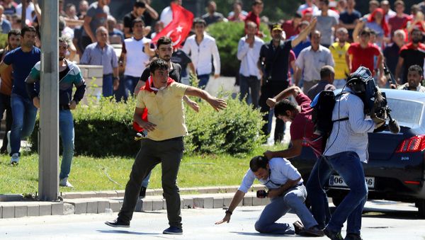Supporters of Turkey's President Recep Tayyip Erdogan, who were staging a protest against a coup, clash with Turkish journalists near the Turkish military headquarters, in Ankara, Turkey, Saturday, July 16, 2016 - Sputnik International