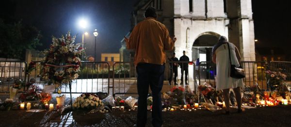 People stand in front of a makeshif memorial near two gendarmes guarding the Saint-Etienne du Rouvray church on July 27, 2016, after the priest Jacques Hamel was killed on July 26 in the church during a hostage-taking claimed by Islamic State group - Sputnik International