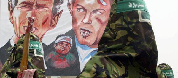 Masked Palestinian members of the Islamic militant group Hamas, march with a larger banner showing a fanged US President George W. Bush (L) and a similar depiction of British Prime Minister Tony Blair during an anti-war protest in the Nusairat refugee camp 04 April 2003, in the Gaza Strip. Masked Palestinian members of the Islamic militant group Hamas, march with a larger banner showing a fanged US President George W. Bush (L) and a similar depiction of British Prime Minister Tony Blair during an anti-war protest in the Nusairat refugee camp 04 April 2003, in the Gaza Strip. - Sputnik International