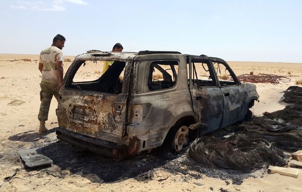 Men inspect the wreckage of a vehicle following clashes between forces loyal to eastern Libyan commander Khalifa Haftar and Benghazi Defence Brigades (BDB), an Islamist-leaning armed group, in the Magrun area, south of Benghazi, Libya July 21, 2016. - Sputnik International