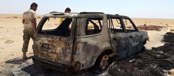 Men inspect the wreckage of a vehicle following clashes between forces loyal to eastern Libyan commander Khalifa Haftar and Benghazi Defence Brigades (BDB), an Islamist-leaning armed group, in the Magrun area, south of Benghazi, Libya July 21, 2016. - Sputnik International