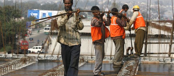 Indian workers carry metal rods on an overpass bridge in Jammu, India - Sputnik International