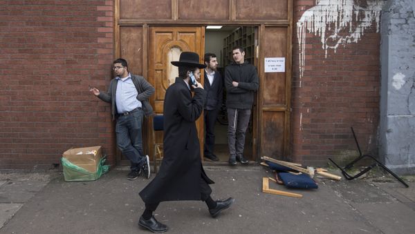 An Orthodox jew talks on his mobile phone as he walks past the Ahavas Torah synagogue in the Stamford Hill area of north London on March 22, 2015 An Orthodox jew talks on his mobile phone as he walks past the Ahavas Torah synagogue in the Stamford Hill area of north London on March 22, 2015 - Sputnik International