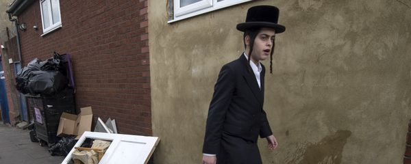 An Orthodox jew walks past a damaged door belonging to the Ahavas Torah synagogue in the Stamford Hill area of north London on March 22, 2015 - Sputnik International