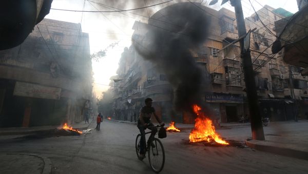 A man rides a bicycle past burning tyres, which activists said are used to create smoke cover from warplanes, in Aleppo, Syria August 1, 2016 A man rides a bicycle past burning tyres, which activists said are used to create smoke cover from warplanes, in Aleppo, Syria August 1, 2016 - Sputnik International
