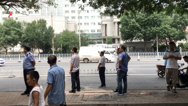 Chinese policemen in plain clothes stand as they stop journalists from taking pictures and video footage in front of the Number 2 Intermediate People's Court in Tianjin on August 4, 2016 Chinese policemen in plain clothes stand as they stop journalists from taking pictures and video footage in front of the Number 2 Intermediate People's Court in Tianjin on August 4, 2016 - Sputnik International