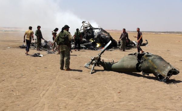 A picture taken on August 1, 2016 shows Syrian rebels gathering around the wreckage of a Russian Mi-8 military transport helicopter after it was shot down along the administrative border between Idlib province, northwestern Syria and neighbouring Aleppo - Sputnik International