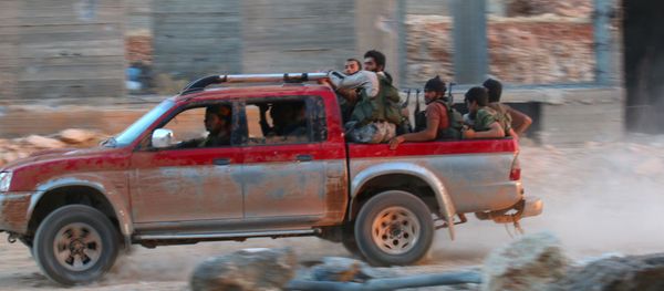 Fighters of the Syrian Islamist rebel group Jabhat Fateh al-Sham, the former al Qaeda-affiliated Nusra Front, ride on a pick-up truck in the 1070 Apartment Project area in southwestern Aleppo, Syria August 5, 2016 - Sputnik International