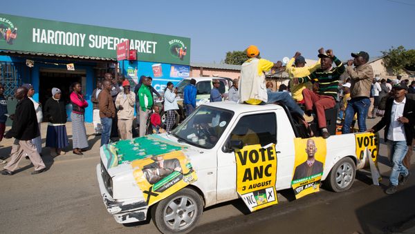 An ANC party vehicle appeals for votes as locals are seen outside a voting station during the Local Government elections in Diepsloot township, north of Johannesburg, South Africa - Sputnik International