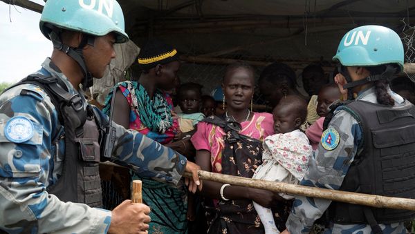United Nations peacekeepers control South Sudanese women and children before the distribution of emergency food supplies at the United Nations protection of civilians (POC) site 3 hosting about 30,000 people displaced during the recent fighting in Juba, South Sudan, July 25, 2016 - Sputnik International