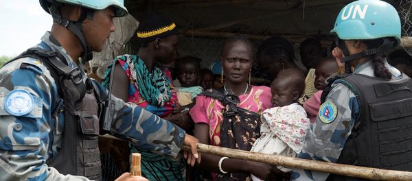 United Nations peacekeepers control South Sudanese women and children before the distribution of emergency food supplies at the United Nations protection of civilians (POC) site 3 hosting about 30,000 people displaced during the recent fighting in Juba, South Sudan, July 25, 2016 - Sputnik International
