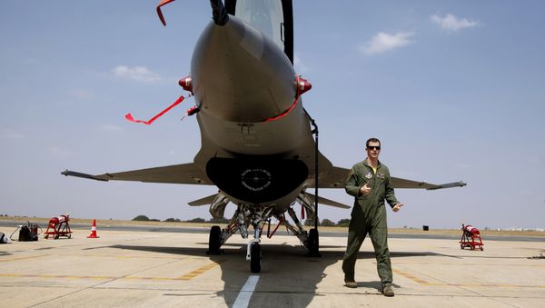 US Air Forces F-16 demonstration team pilot, Ryan Worrell from Iowa, walks past the F-16, a fighter aircraft, on display on the fourth day of the Aero India 2013 at Yelahanka air base in Bangalore, India, Saturday, Feb. 9, 2013 - Sputnik International