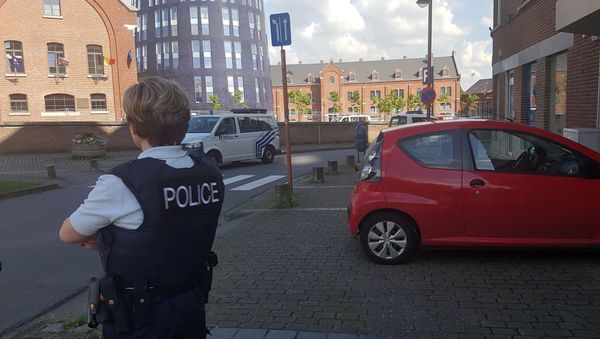 A photo taken with a mobile phone on August 6, 2016, shows a police officer standing guard close to a police building in the southern Belgian city of Charleroi following a machete attack A photo taken with a mobile phone on August 6, 2016, shows a police officer standing guard close to a police building in the southern Belgian city of Charleroi following a machete attack - Sputnik International