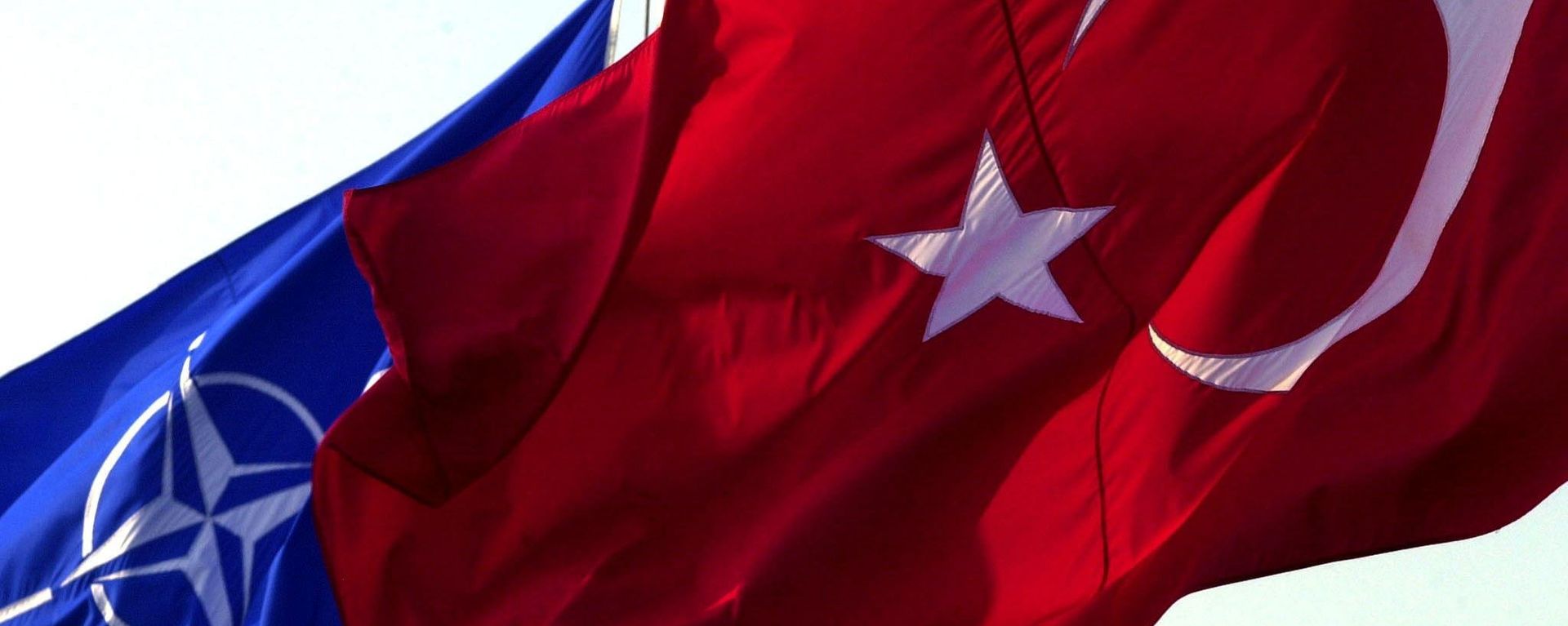 A Turkish flag waves in front of NATO's one - Sputnik International, 1920, 05.04.2023