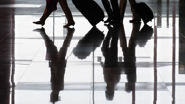 Travellers and their luggage are reflected on the floor at Terminal 3 of Beijing's Capital International Airport. (File) - Sputnik International