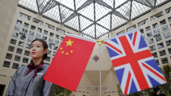 A member of staff stands behind flags as officials arrive for the UK-China High Level Financial Services Roundtable at the Bank of China head office building in Beijing on July 22, 2016 A member of staff stands behind flags as officials arrive for the UK-China High Level Financial Services Roundtable at the Bank of China head office building in Beijing on July 22, 2016 - Sputnik International