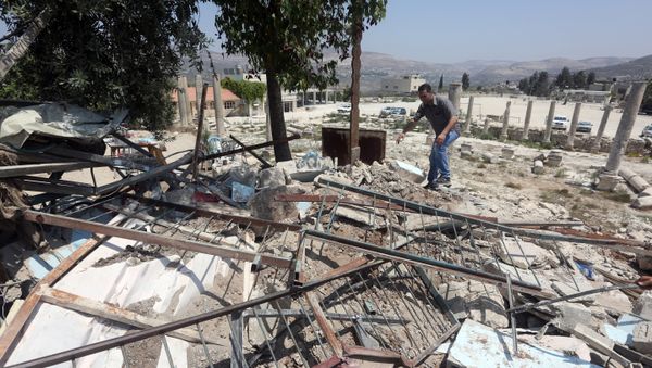 A Palestinian man walks amidst debris after Israeli authorities demolished a building in the village of Sebastia, near Nablus, in the Israeli-occupied West Bank on August 9, 2016 A Palestinian man walks amidst debris after Israeli authorities demolished a building in the village of Sebastia, near Nablus, in the Israeli-occupied West Bank on August 9, 2016 - Sputnik International