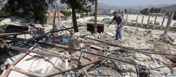 A Palestinian man walks amidst debris after Israeli authorities demolished a building in the village of Sebastia, near Nablus, in the Israeli-occupied West Bank on August 9, 2016 A Palestinian man walks amidst debris after Israeli authorities demolished a building in the village of Sebastia, near Nablus, in the Israeli-occupied West Bank on August 9, 2016 - Sputnik International
