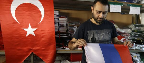 An employee of a flag-making factory folds a Russian flag as a Turkish flag adorns the display at left, in Istanbul, Tuesday, Aug. 9, 2016 - Sputnik International