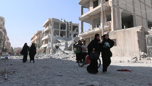 Women react as they walk along a street after they were evacuated with others by the Syria Democratic Forces (SDF) fighters from an Islamic State-controlled neighbourhood of Manbij, in Aleppo Governorate, Syria, August 12, 2016 - Sputnik International