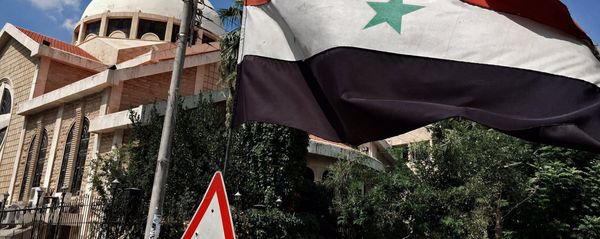 A state flag of the Syrian Arab Republic by an Orthodox church in an old Christian block of Aleppo, Syria - Sputnik International