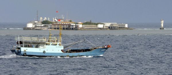 Chinese fishing vessel sails by Fiery Cross Reef, background, also known as Yongshu Reef, of the Spratly Islands in South China Sea. File photo. Chinese fishing vessel sails by Fiery Cross Reef, background, also known as Yongshu Reef, of the Spratly Islands in South China Sea. File photo. - Sputnik International