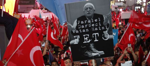 Supporters of Turkish President Recep Tayyip Erdogan wave their national flags and hold a portrait of Fethullah Gulen, a U.S.-based Muslim cleric with Turkish words that read: the Coup nation traitor, FETO (Feto is the nickname of Fethullah Gulen), during a pro-government rally at Kizilay main square, in Ankara, Turkey, Wednesday, July 20, 2016 - Sputnik International