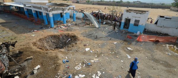 People look at a crater caused by a Saudi-led coalition air strike at the yard of a hospital operated by Medecins Sans Frontieres in the Abs district of Hajja province, Yemen - Sputnik International