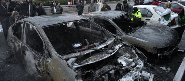 People react as they stand around cars gutted by fire in the Stockholm suburb of Rinkeby People react as they stand around cars gutted by fire in the Stockholm suburb of Rinkeby - Sputnik International