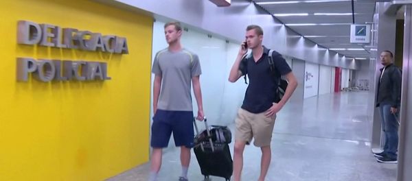 U.S. Olympic swimmers Gunnar Bentz and Jack Conger walk to the airport police station office at Rio's international airport in this still frame taken from video dated August 17, 2016, in Rio De Janeiro, Brazil. - Sputnik International
