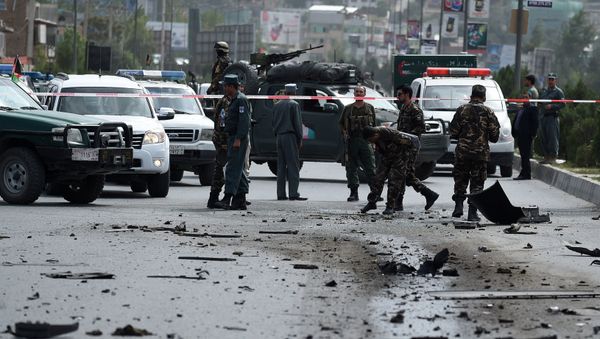 Afghan security personnel inspect a damaged car at the site of a sticky bomb attack in Kabul on August 18, 2016 - Sputnik International