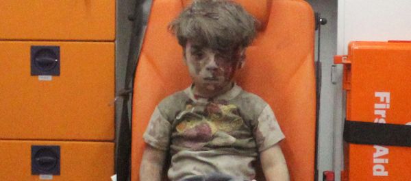 Five-year-old Omran Daqneesh, with bloodied face, sits inside an ambulance after he was rescued following an airstrike in the rebel-held al-Qaterji neighbourhood of Aleppo, Syria August 17, 2016. - Sputnik International